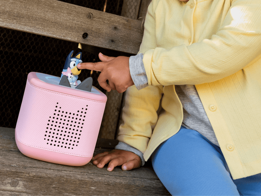 child playing with a pink toniebox 2 and a bluey tonie audio figurine for kids